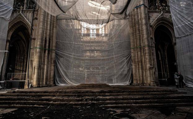 Imagen principal - La obra del siglo. De izquierda a derecha. Aspecto devastado de la nave central tras el incendio y bomberos supervisando el estado de la cubierta. Debajo, los técnicos se afanan en consolidar la estructura. 