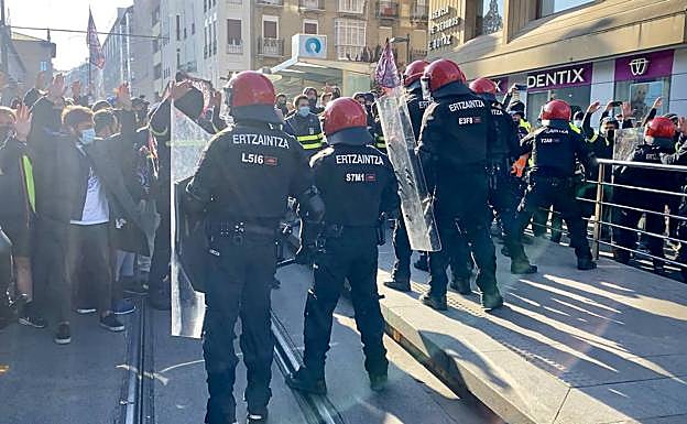 Imagen principal - Algunos momentos de tensión de la protesta vivida esta mañana de viernes frente al Parlamento vasco. 