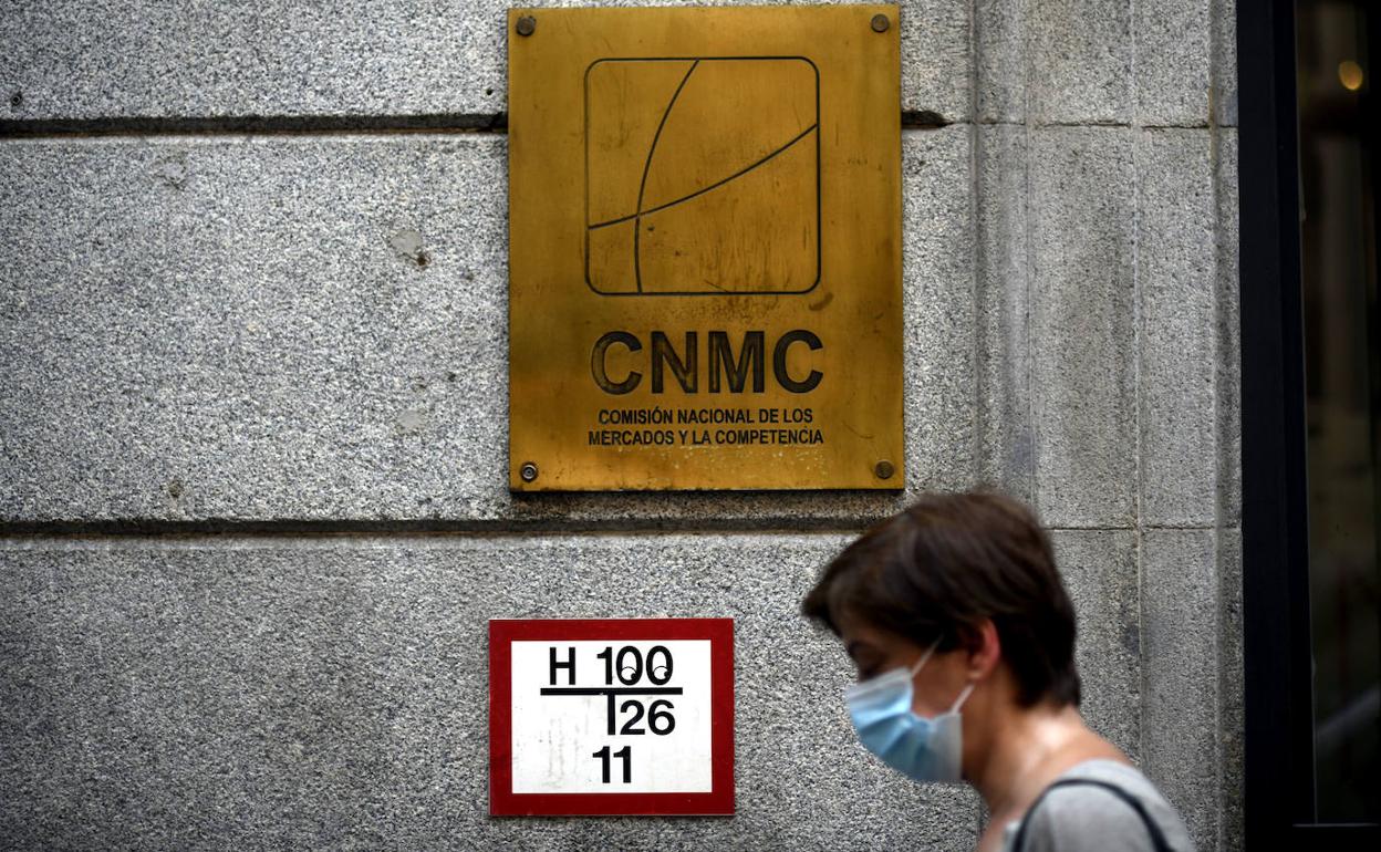 Una persona camina por delante de la sede de la CNMC, en Madrid.