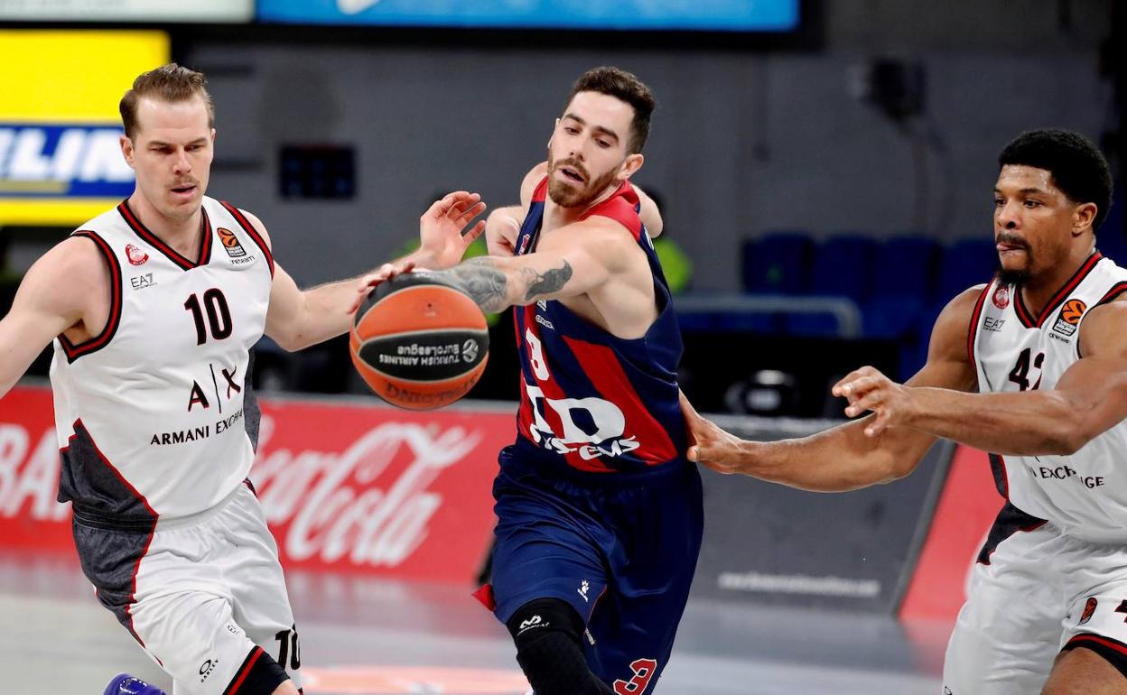 Luca Vildoza trata de superar a los estadounidenses Michael Roll y Kyle Hines, del Olimpia Milán, durante un partido reciente de EuroLiga.