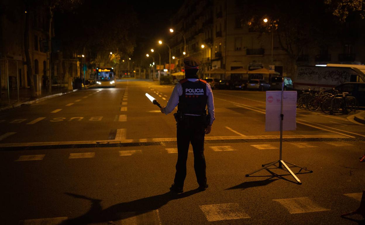 Un mosso controla el toque de queda por las calles de Barcelona.