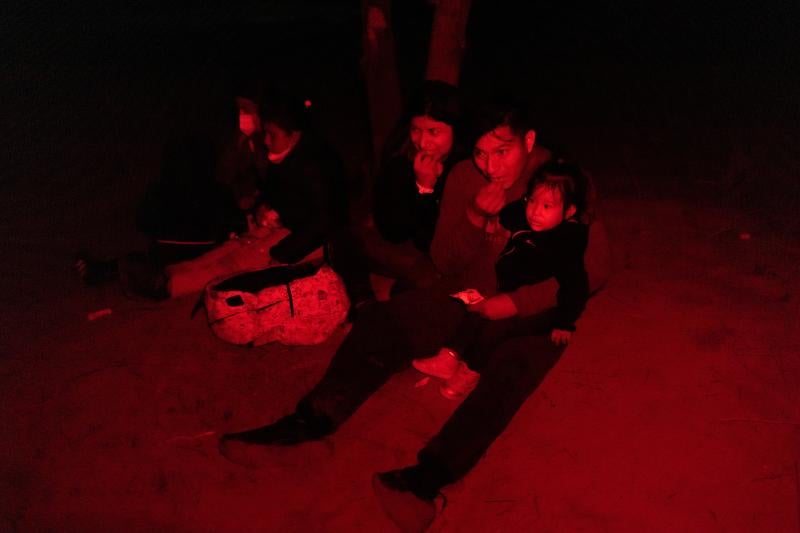 Jonathan ha llegado a la frontera desde Ecuador. En la foto, come de un paquete de frutas y nueces, mientras llora junto a su esposa. Yasmin, que sostiene a su hija de un año, Noa.