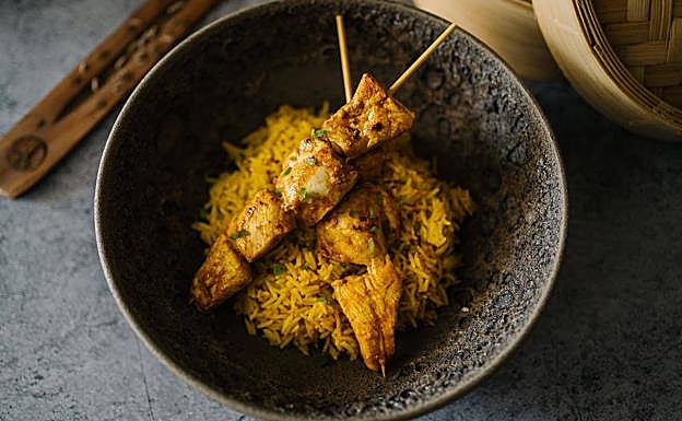 Sekuwa o brochetas de pollo con arroz basmati al curry, un reconstituyente y especiado platillo nepalí. 