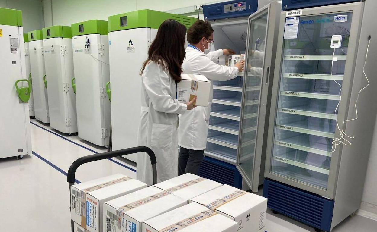 Dos técnicos meten en cámaras frigoríficas las vacunas de AstraZeneca. 