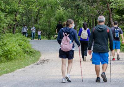 Imagen secundaria 1 - Arriba, dos familias de Santurtzi en el parketxe de Gorbeia. Debajo, gente de ruta en el parque natural. 
