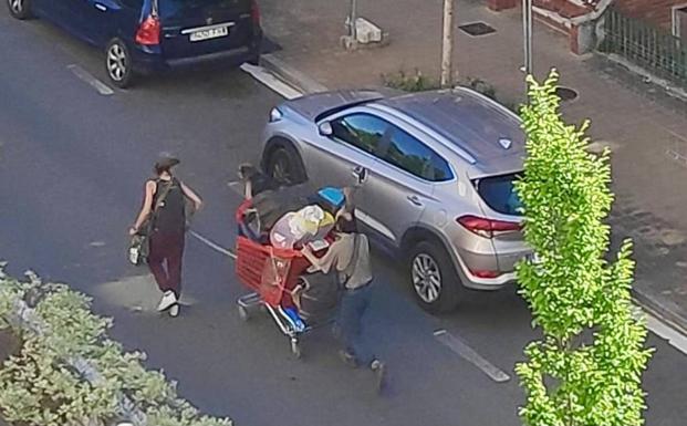 Un par de okupas salen esta tarde de lunes de los bloques de Olárizu con un carrito cargado de enseres. 