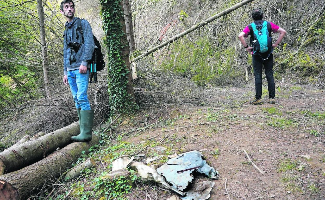 Rubén Santos y Alberto Bóveda (de espaldas) junto a un resto de fuselaje del avión de Iberia siniestrado, de tamaño considerable. 