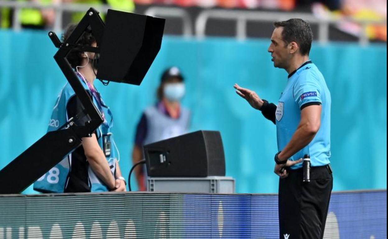 El argentino Rapallini consulta una posible mano durante el Ucrania-Macedonia del Norte. 