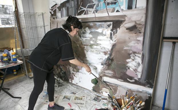 Imagen principal - La artista trabaja en una obra que sitúa las chabolas en torno a una cloaca al aire libre. Una pieza inédita de 1994, que pone a la mujer ante el tiempo de secado de una colada en forma de redes y con unas pautas de caligrafía de fondo. Un detalle de un cuadro donde Arrazola plasma la mirada de los desheredados. 