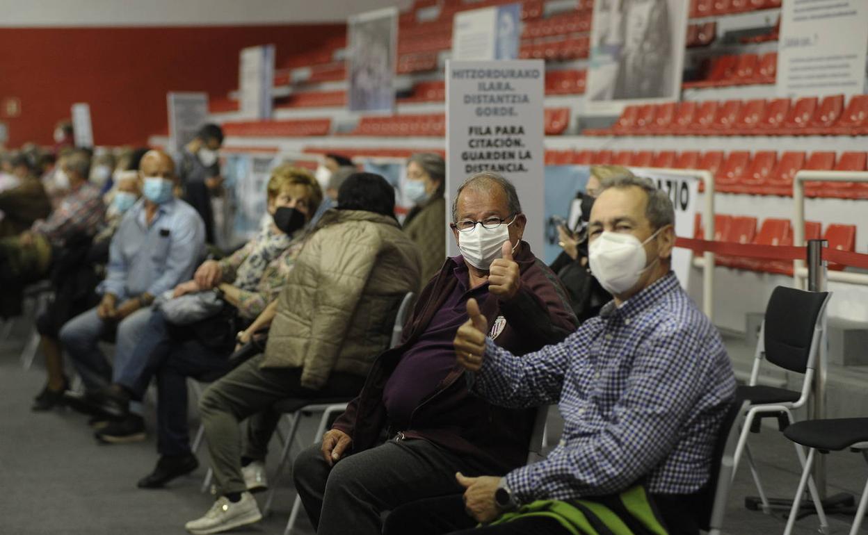 Dos hombres celebran el haber recibido la vacuna. 