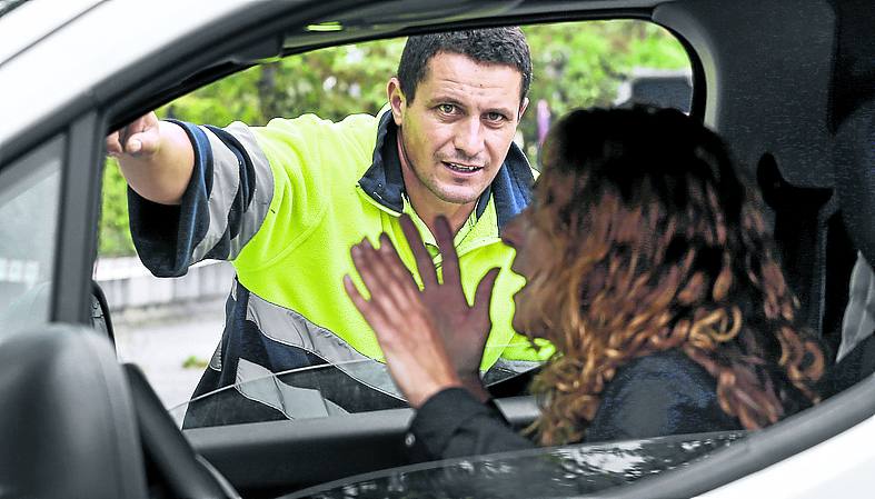 Un operario da indicaciones a una conductora.