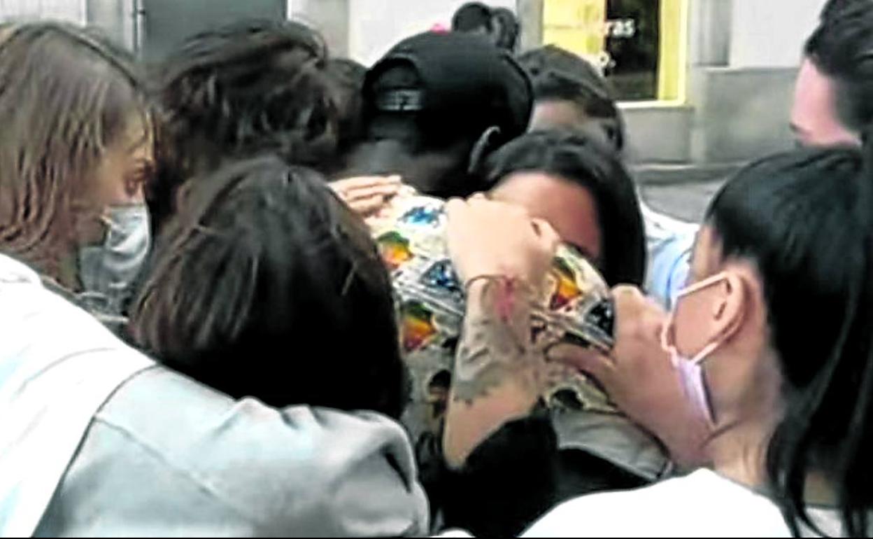 Uno de los dos senegaleses en situación irregular que intentaron ayudar a Samuel recibe el abrazo de las amigas del joven coruñés asesinado. 