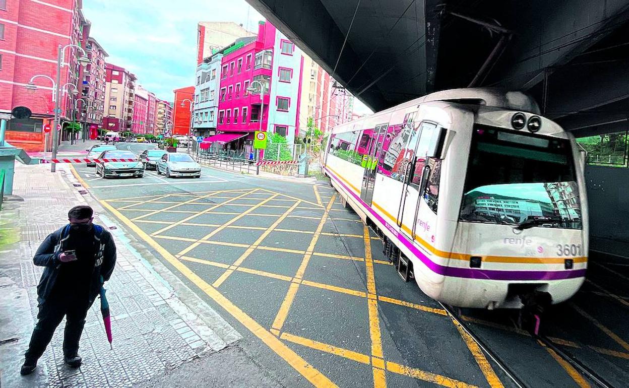 Un tren pasa por el paso a nivel situado bajo el viaducto de la autopista, escenario de numerosos accidentes, en una imagen captada ayer. 