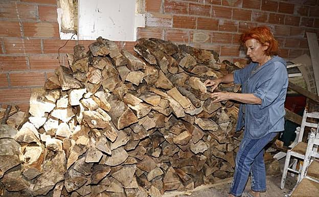 Ana Villanueva coloca leña en el almacén que tiene en su caserío. 
