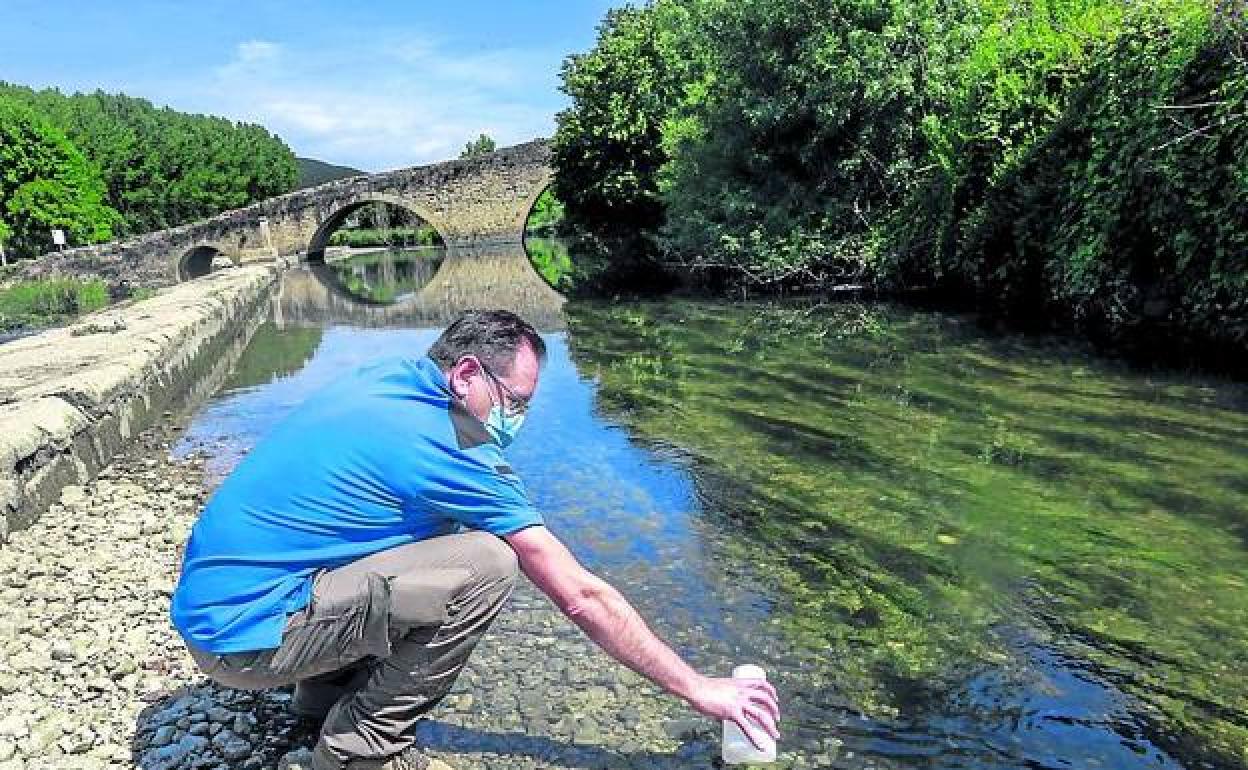 Roberto Ortiz saca una muestra de agua del Zadorra. 