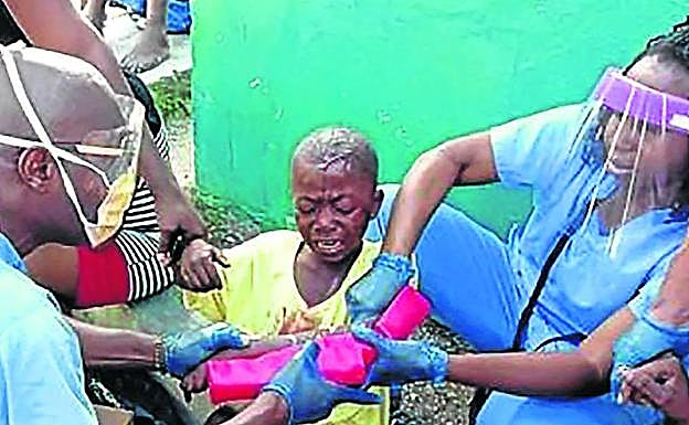 Médicos desplazados desde Cuba asisten a una niña que sufrió una rotura de brazo a causa del seísmo en Jerèmie.