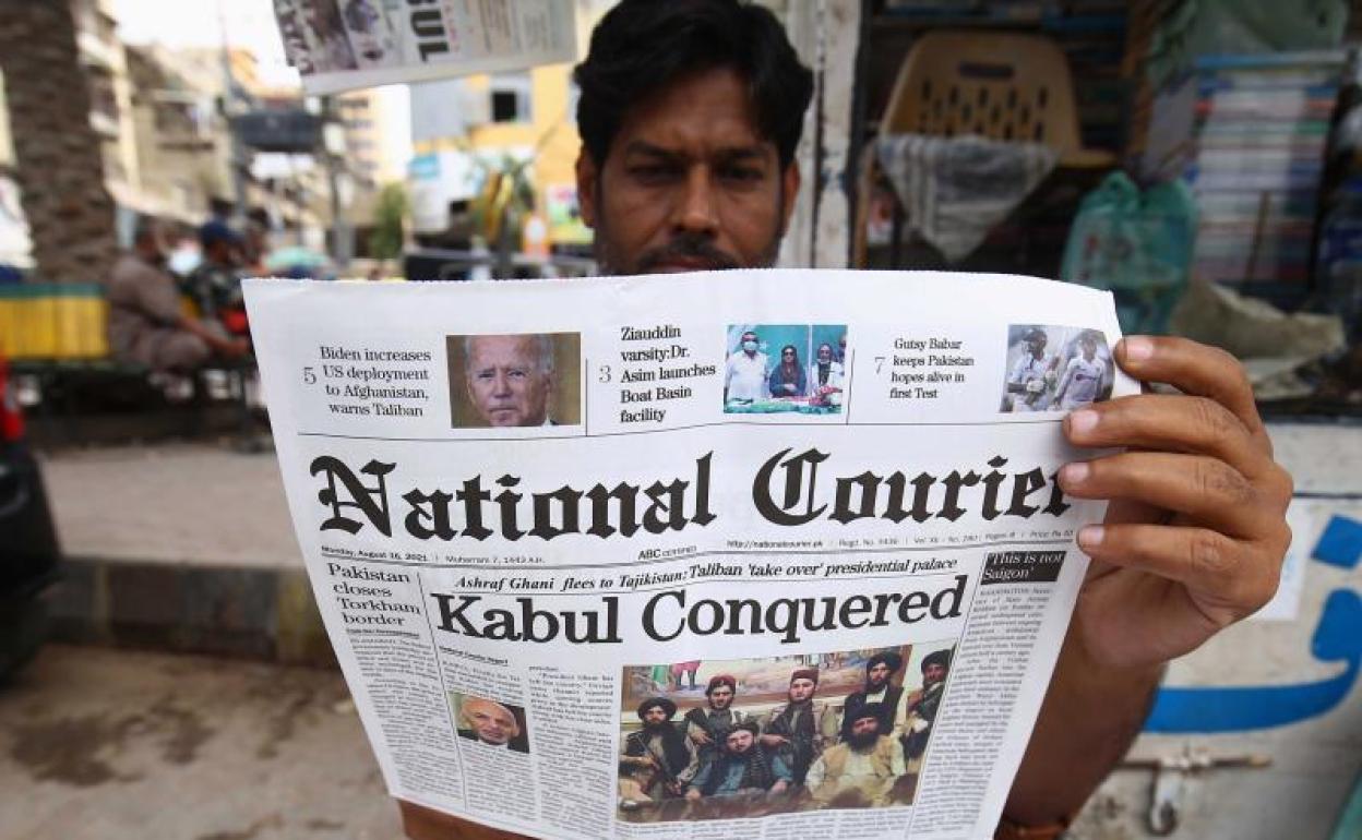 Un pakistaní lee en la prensa local la noticia de la caída de Kabul. 