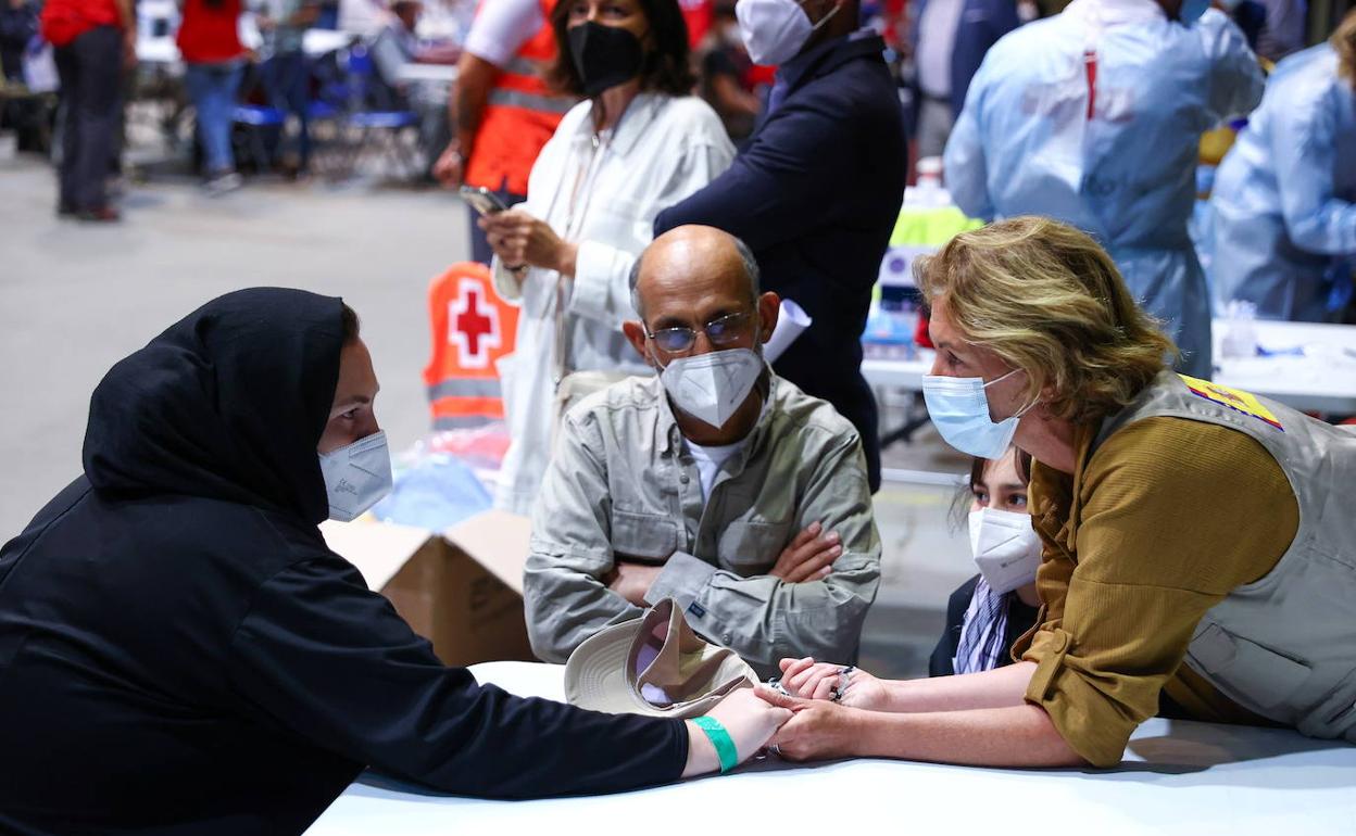 Gesto reconfortante hacia una mujer refugiada que llegó ayer con su familia a la base de Torrejón. 