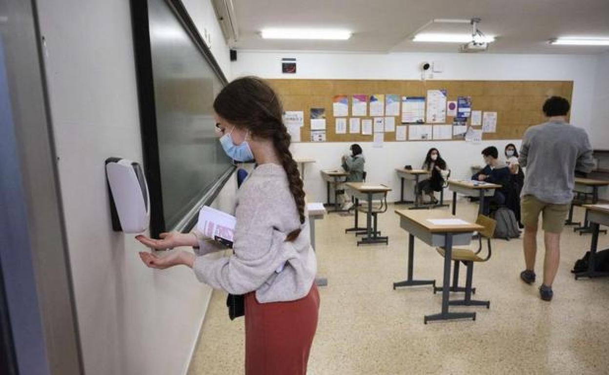 Una estudiante coge gel hidroalcohólico para limpiarse las manos. 