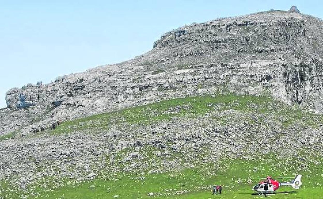 Un ertzaina y un miembro de la Cruz Roja asisten a un montañero accidentado en el Gorbea. 