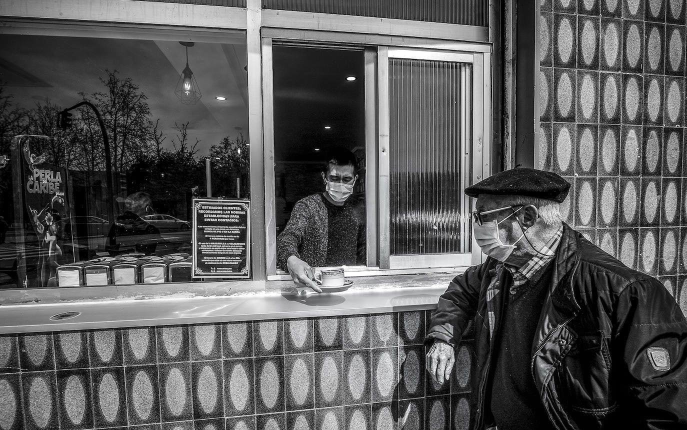 Mario, del bar La Paloma, atiende a un cliente al otro lado de la ventana.