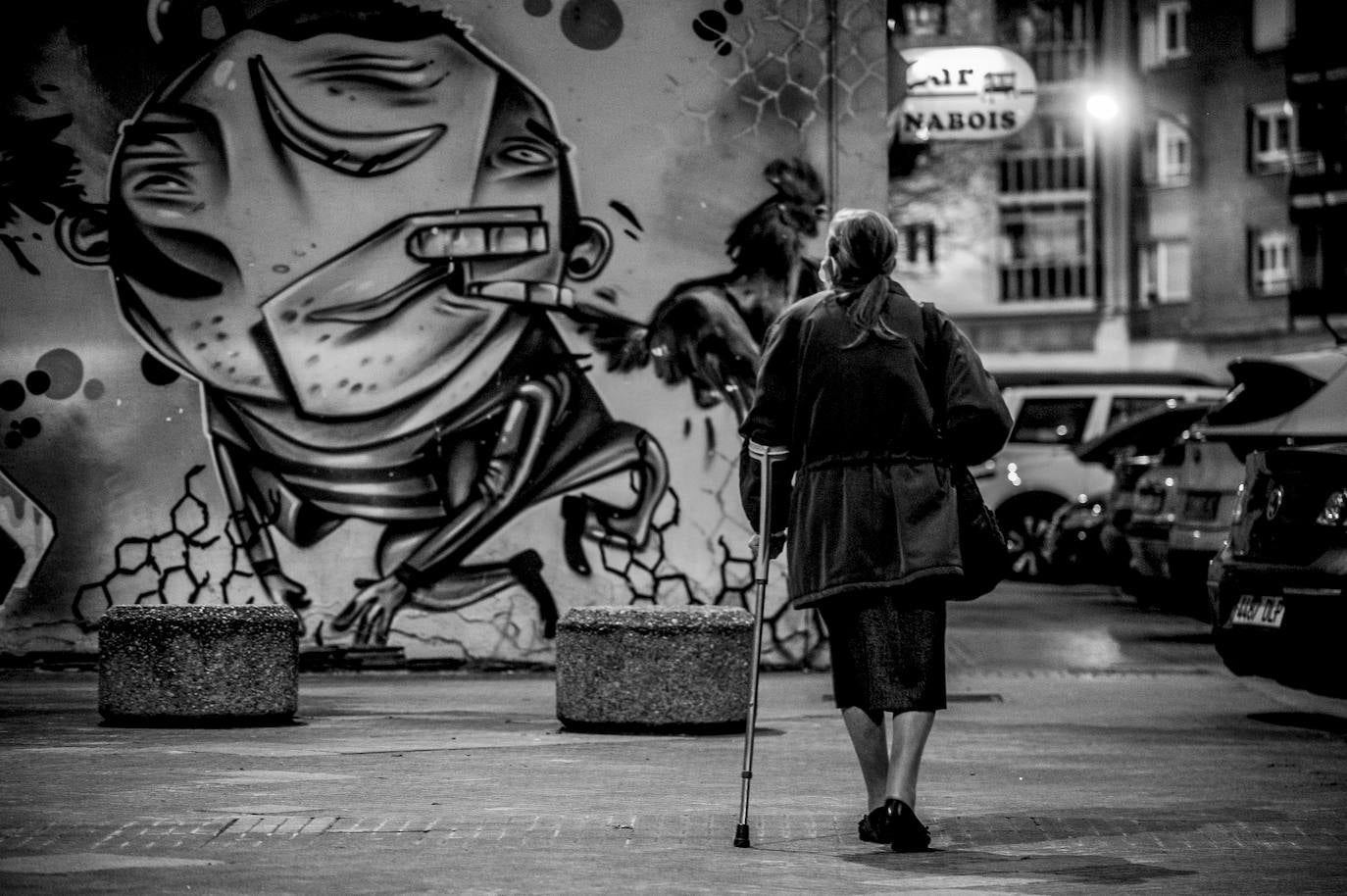 Una mujer observa el grafiti de la calle Lorenzo Prestamero.