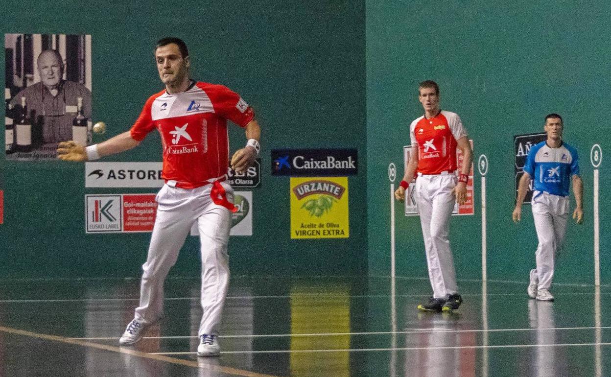 Elezkano II ejecuta un saque ante la atenta mirada de su compañero Mariezkurreena II y Rezusta.