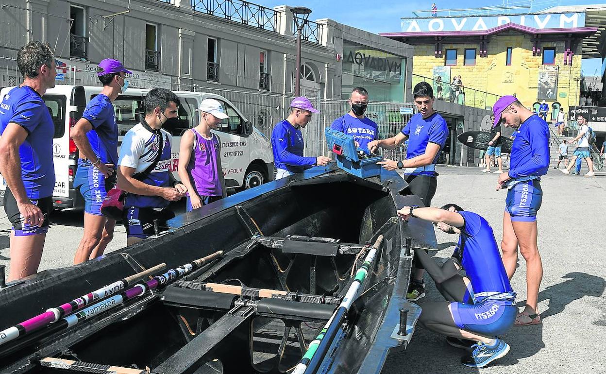 Los remeros y entrenador de Santurtzi preparan la trainera en el puerto de San Sebastián antes de salir a entrenar ayer. 