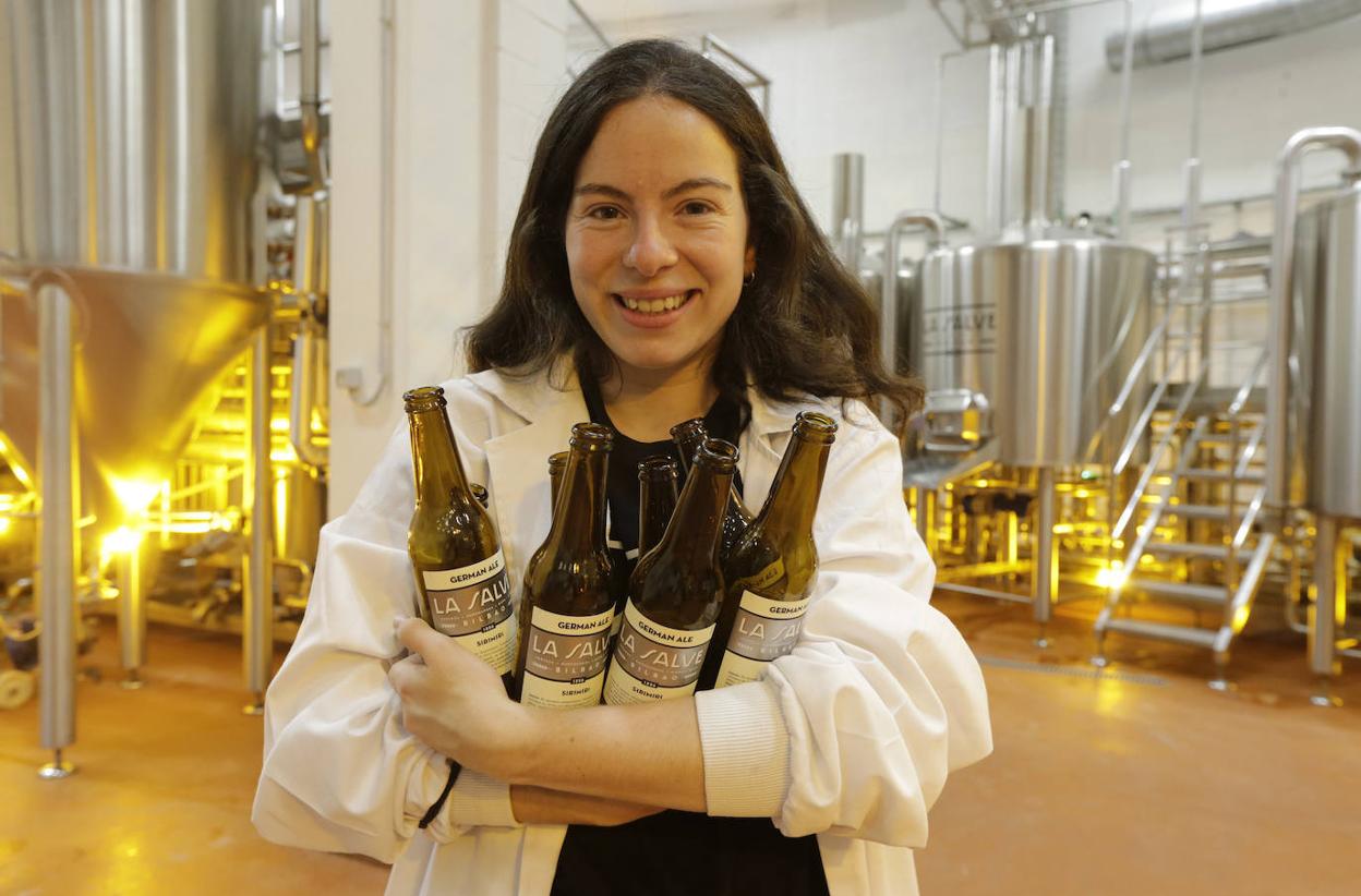 La maestra cervecera de la marca bilbaína sostiene algunas botellas en la planta de Bolueta.