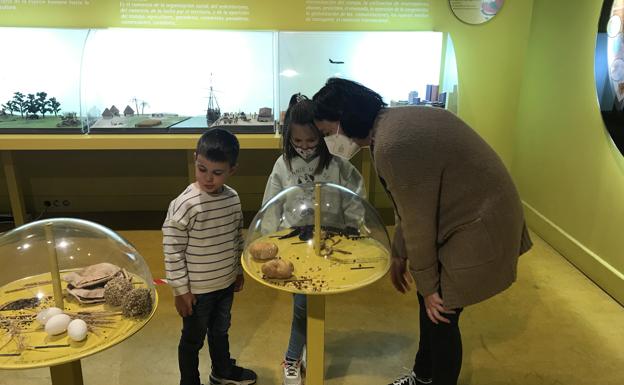 Una mujer explica a dos niños detalles relativos a la alimentación en el centro D'Elikatuz.