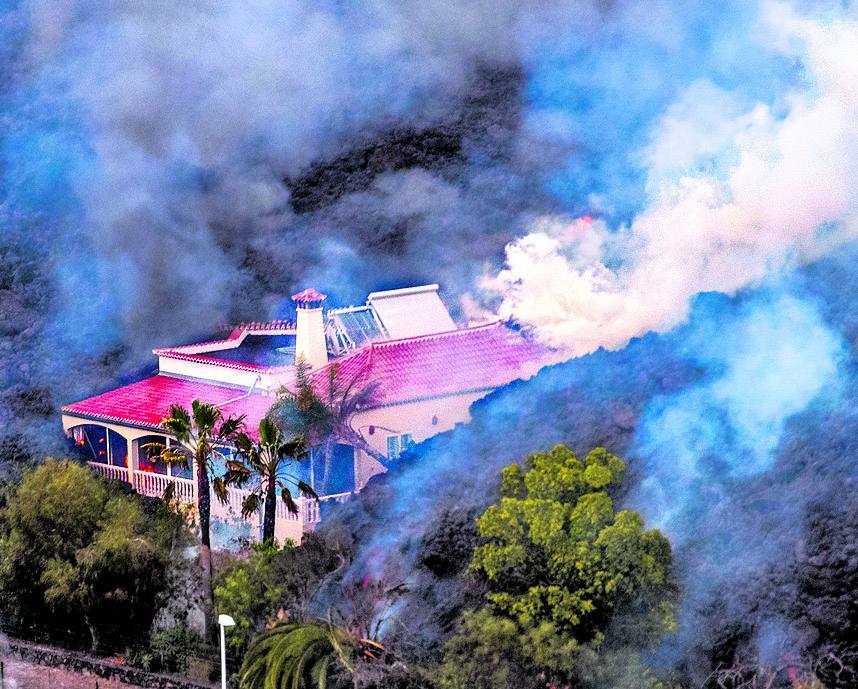 La imparable colada de lava del volcán Cumbre Vieja se acerca a una vivienda. 