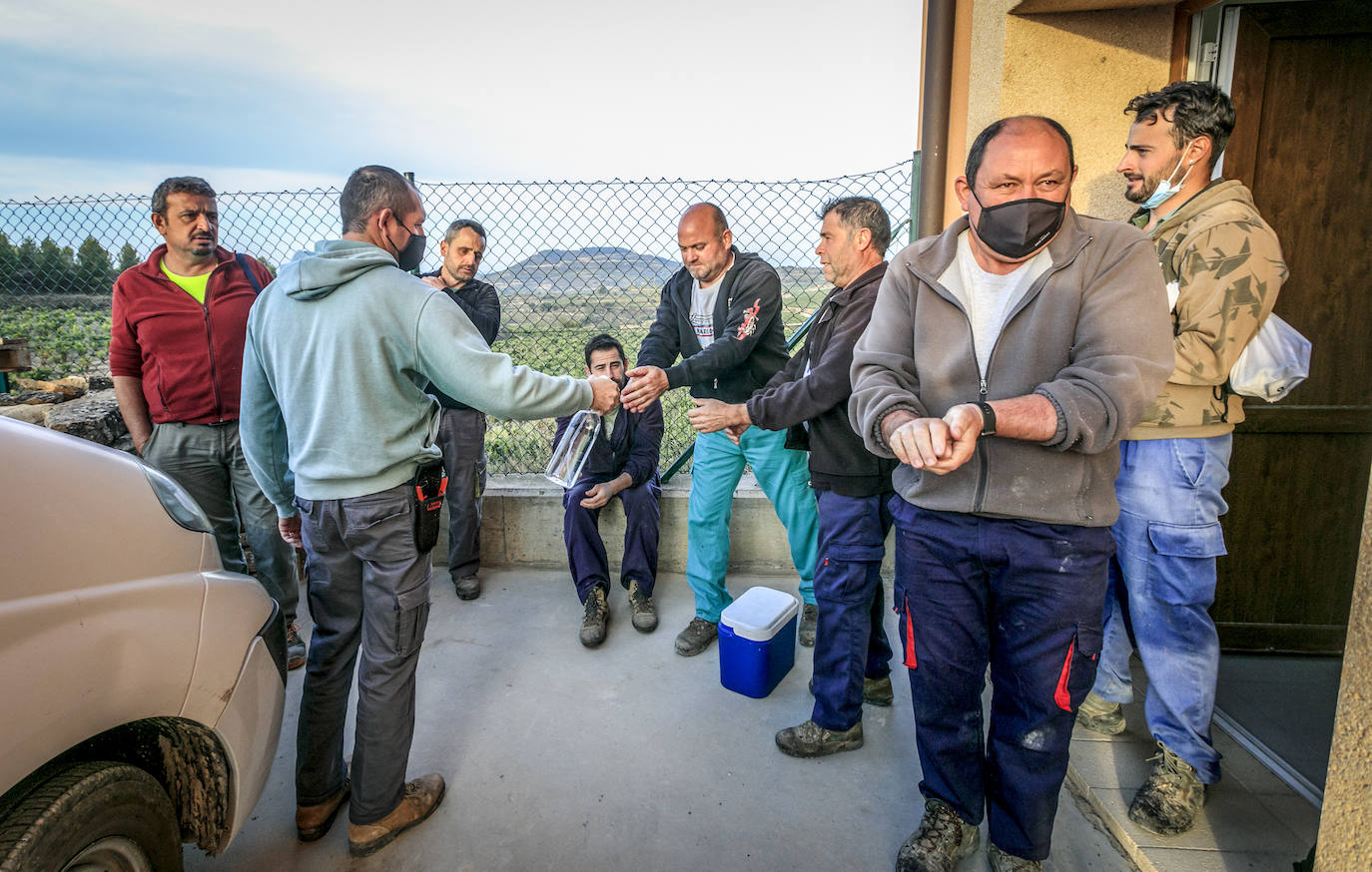 Los temporeros se desinfectan las manos antes de salir del albergue