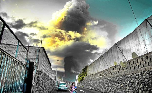 La sombra alargada del volcán. Una mujer deambula por las calles de El Paso ante la amenazadora columna de material piroclástico que desprende del cráter.