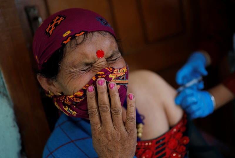 Kamla Devi administra una dosis de la vacuna a otra mujer de la aldea, a la que le asustan las agujas.