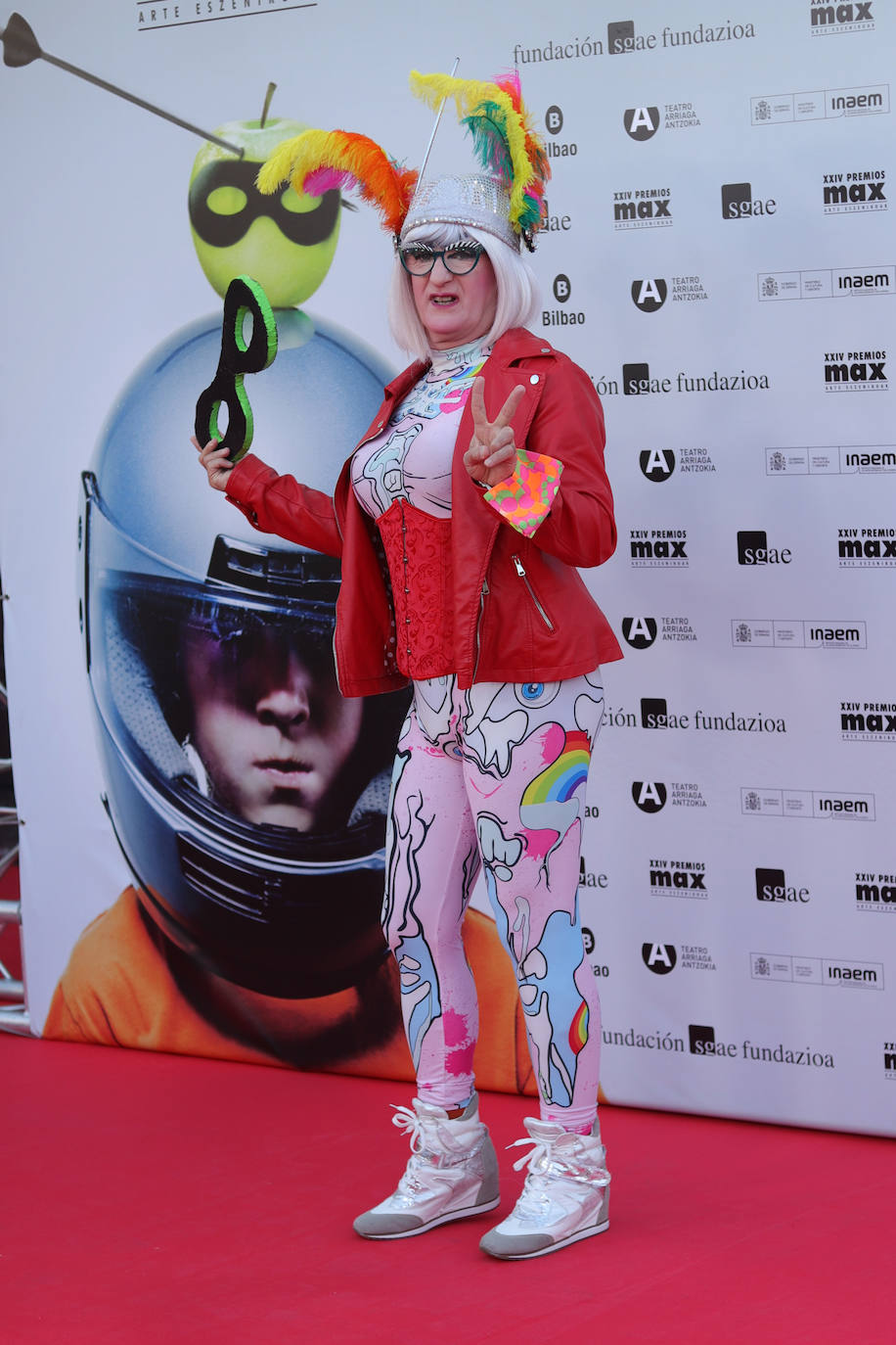 Yogurinha, el personaje creado por las Fellini en 1994 y que se convirtió en símbolo de la libertad sexual, le puso color a la alfombra roja con un diseño de su propia firma, un corsé rojo y una chupa de cuero del mismo color. Además incluyó un tocado de plumas multicolor.