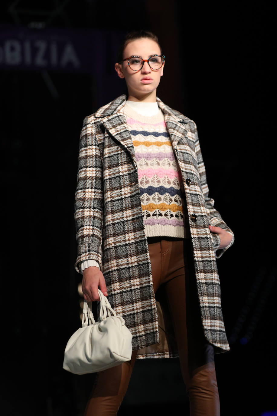Abrigo de cuadros y jersey calado en tonos cálidos.