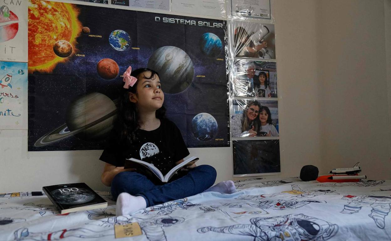 Nicolinha, en su habitación, rodeada de naves espaciales e imágenes del universo. 