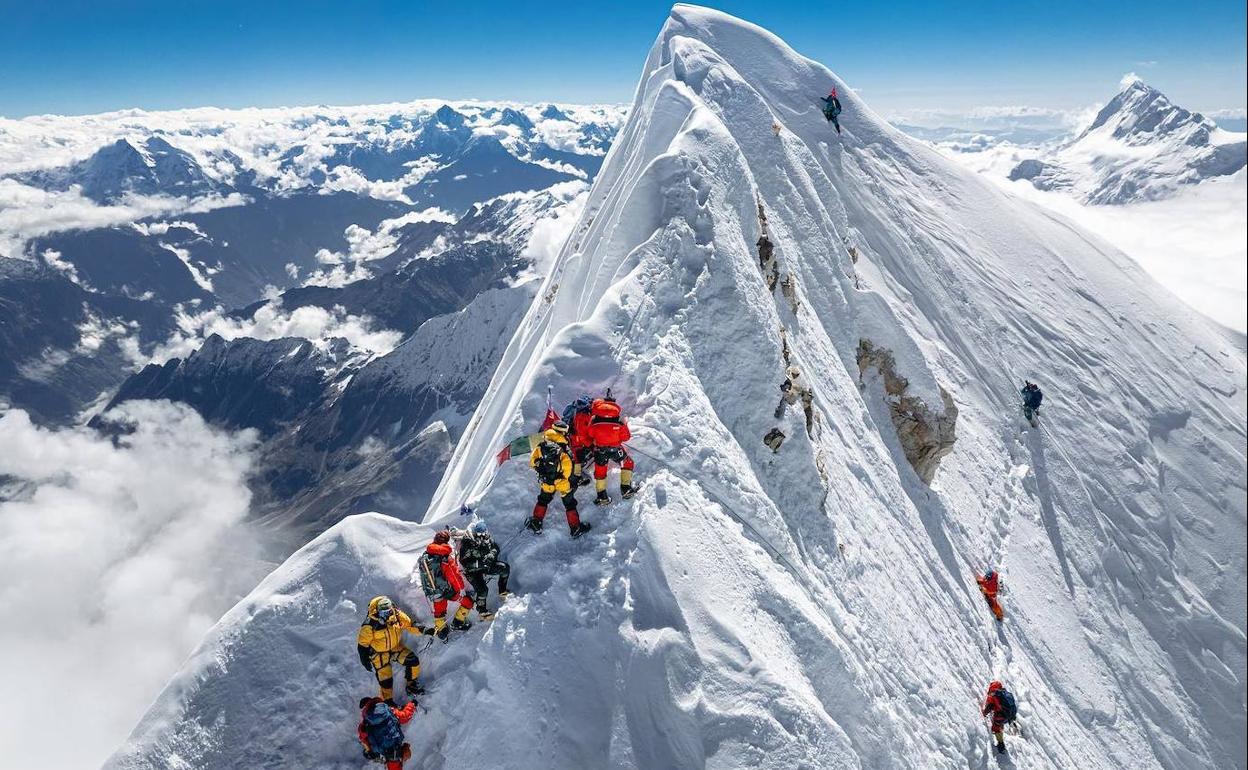 Alpinista talde bat Manasluko gailurrera iritsi da, eta gutxi batzuk, eskuinean, benetako gailurrera igo dira. 