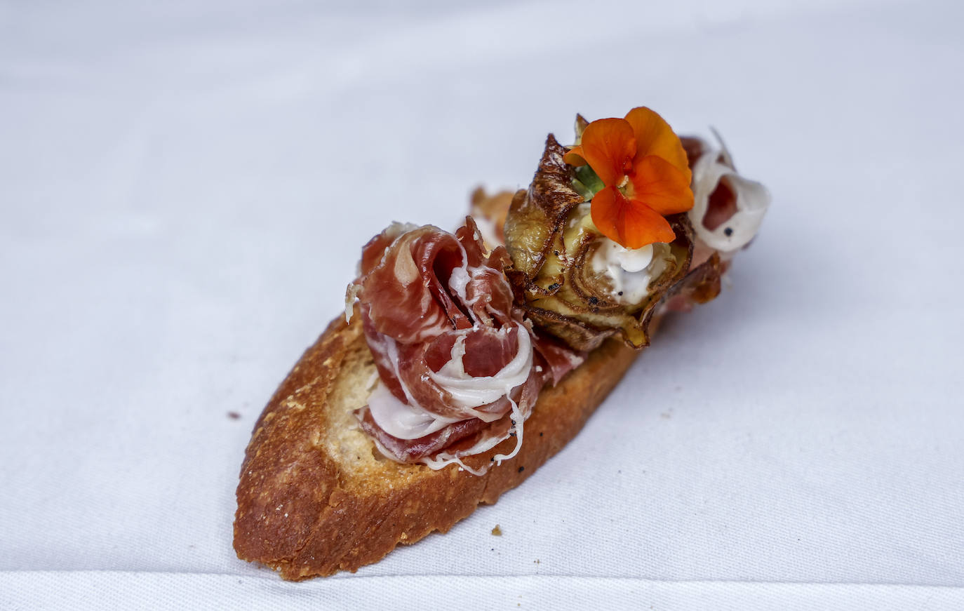 Tosta de jamón ibérico y flor de alcachofa.