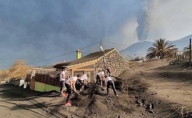 Los voluntarios retiran la ceniza de las casas.