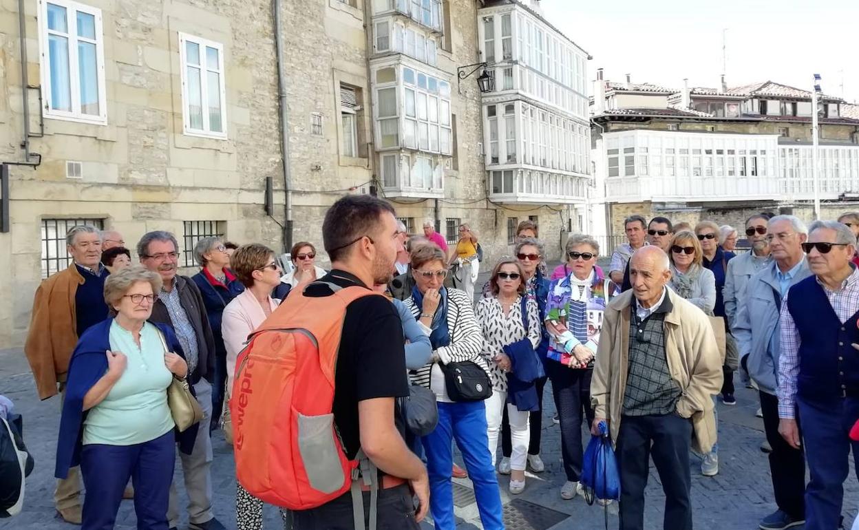 Asistentes a una visita atienden las explicaciones del guía en la plaza del Matxete.