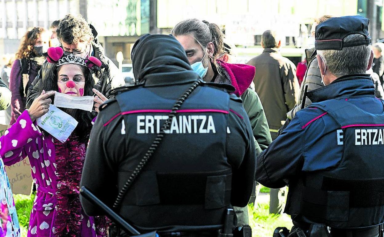 Agentes de la Ertzaintza piden la documentación a varios asistentes a una manifestación en Bilbao. 