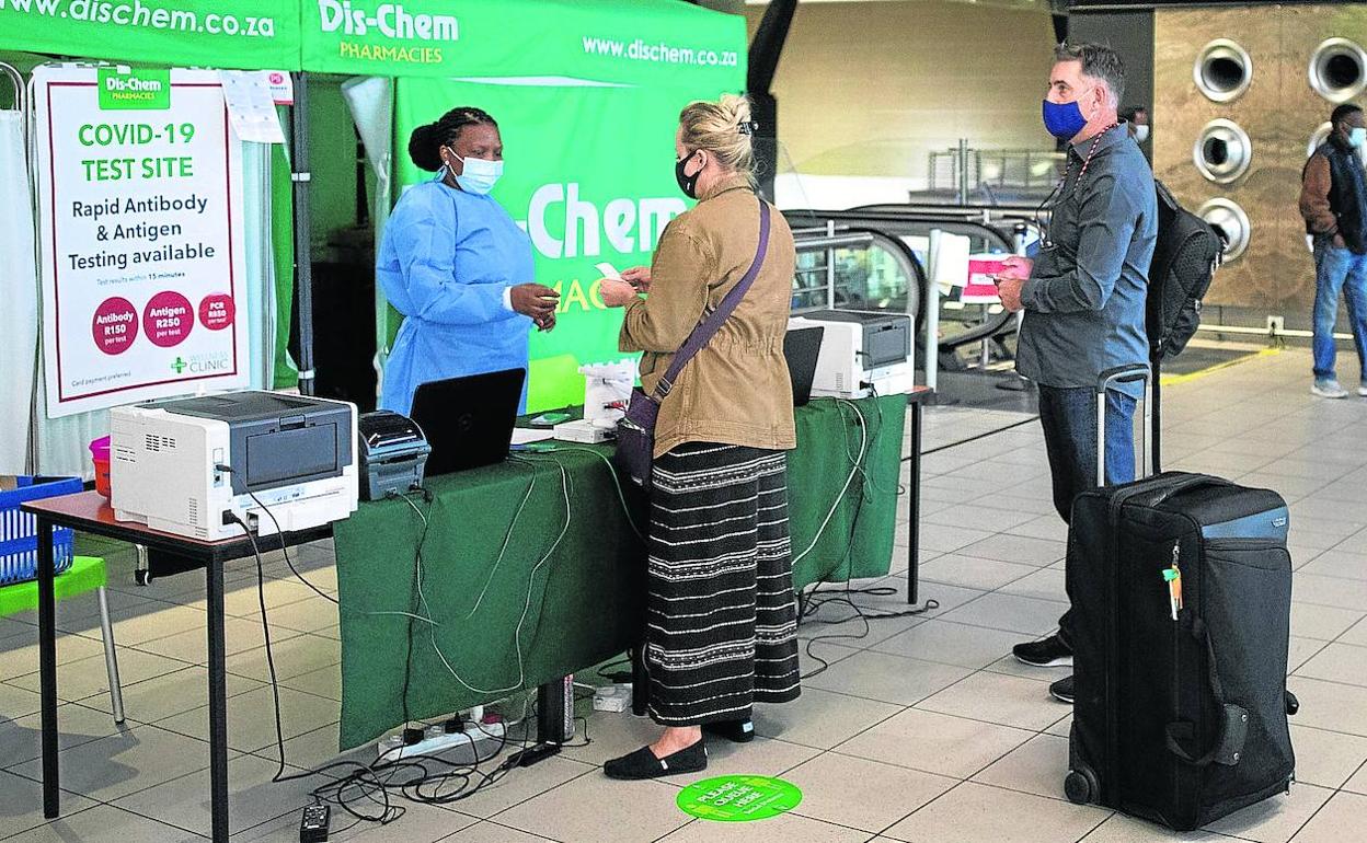 Pasajeros se someten a una prueba de coronavirus en el Aeropuerto Internacional OR Thambo de la ciudad sudafricana de Johannesburgo.