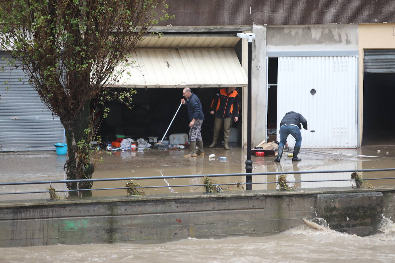 Propietarios limpian las lonjas afectadas por la subida del río en Basauri.