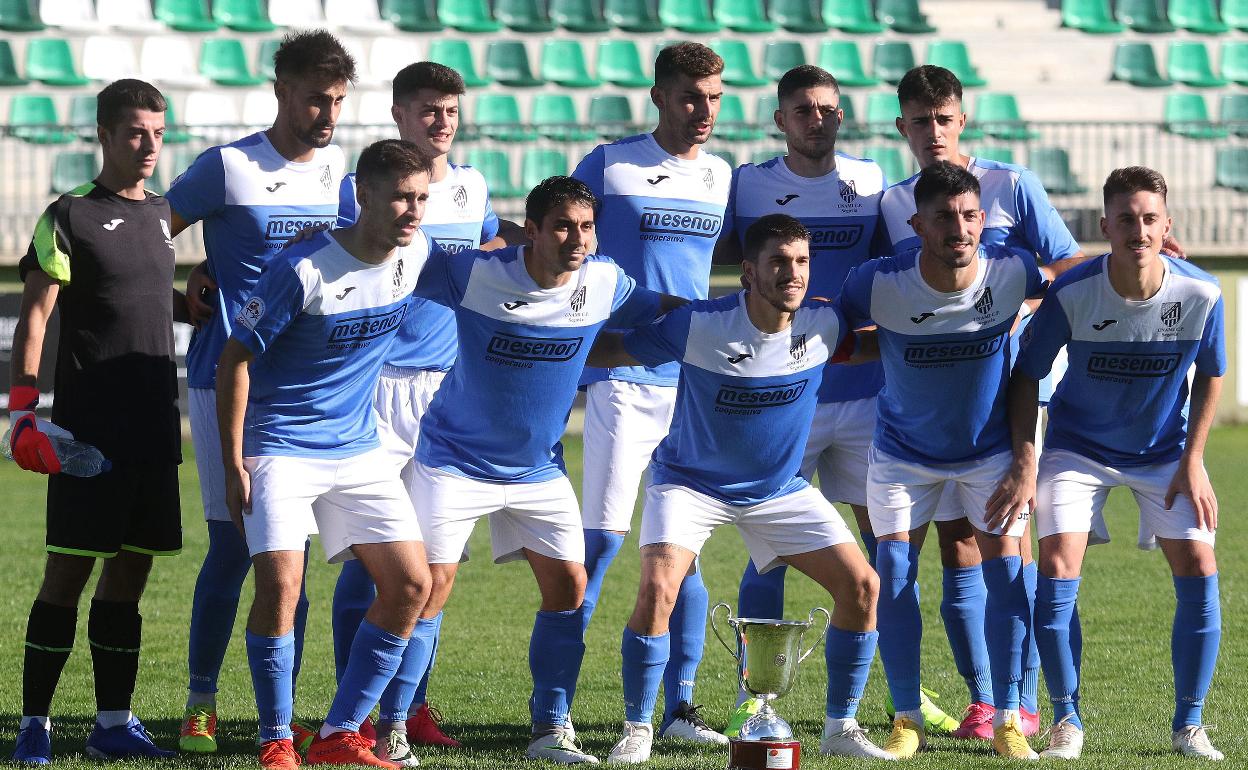 El central y capitán Sergio Prieto, en el centro de la fila inferior, con el brazalete y el trofeo de campeones de la pasada Preferente antes de un duelo de este curso. 