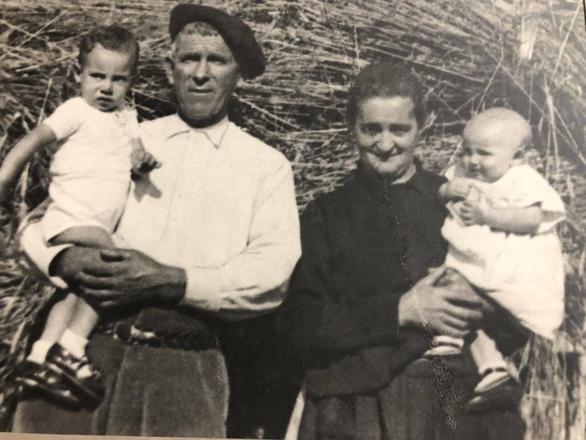 El bisabuelo Jorge y la bisabuela Faustina sostienen a sus hijos a comienzo de los 40, frente a balas de paja dispuestas en una de las eras de Antoñana.