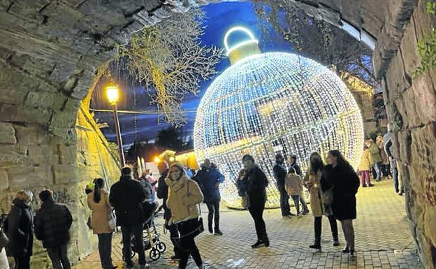 5. El público pasa por el viejo paso del barrio, dominado por una gran bola de luces.