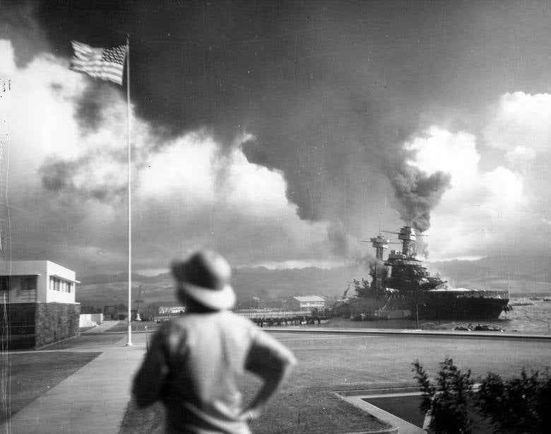 El acorazado USS California dañado, que se inclinó hacia el puerto después de ser alcanzado por torpedos aéreos japoneses y bombas, se ve frente a la isla Ford durante el ataque. Archivos Nacionales / Marina de los EE. UU.