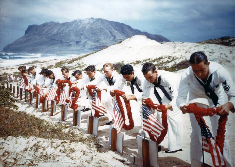 Siguiendo la tradición hawaiana, los marineros honran a los hombres asesinados durante el ataque japonés a Pearl Harbor el año anterior en la estación aérea naval de Kaneohe, el 31 de mayo de 1942. Las víctimas habían sido enterradas el 8 de diciembre de 1941. Armada de los EE. UU. / Archivos Nacionales.