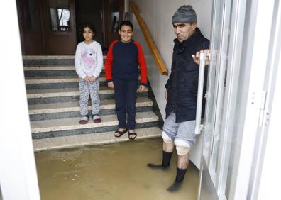Imagen secundaria 1 - Un vecino de Abetxuko en uno de los portales inundados. Abajo, la familia de Hamed se ha quedado hoy en casa. Estampa de un patio del barrio colapsado por la ríada. 